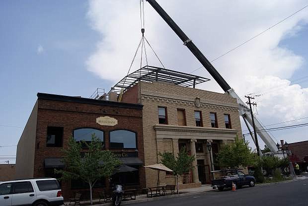 A crane lifts the frame of the new solar array/shade structure on Bently headqarters.