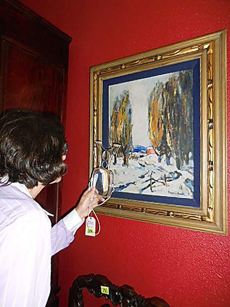 Karin Costa inspecting a Thomas Hunt painting which was auctioned off by her business.