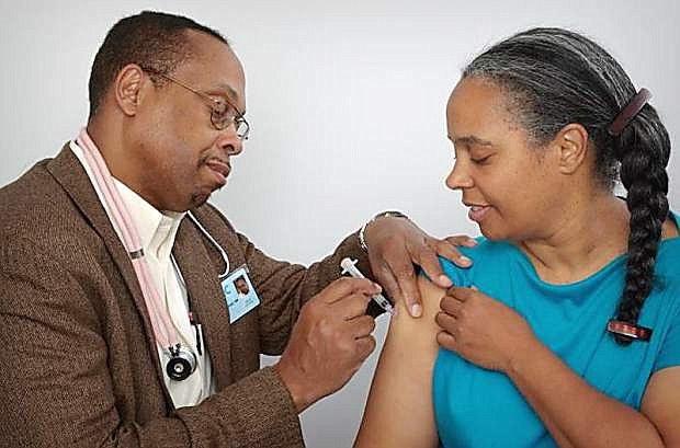 A woman gets administered a vaccination.