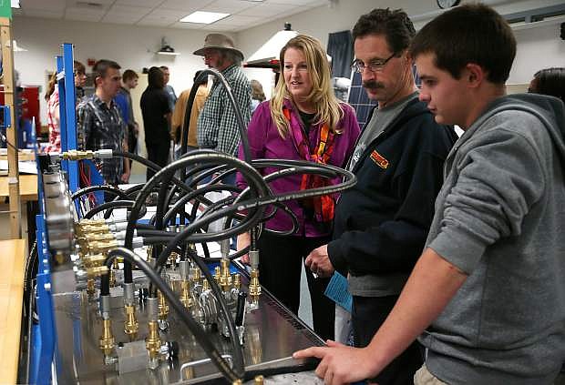 Western Nevada College Computer Information Technology Professor Emily Howarth, left, talks with Skip and Garret Nicholson in the Applied Industrial Technology laboratory at the college during a tour in 2015. The AIT lab is one program where WNC is seeking to train student for new high-tech jobs.