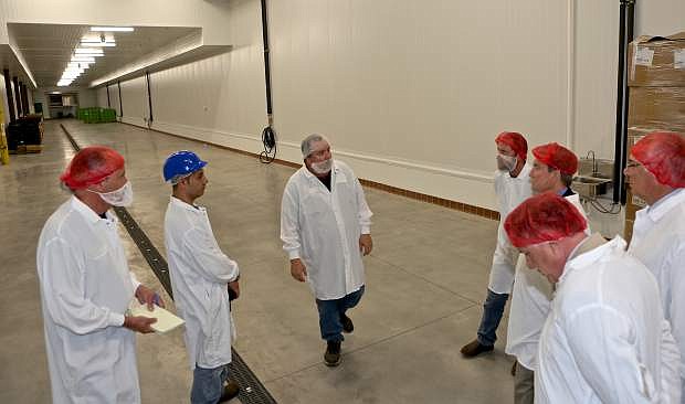 SunOpta Plant Manager John M. Stevens (center) tours city dignitaries and NNDA representatives through a safe food-handling area that will soon start producing for the company.
