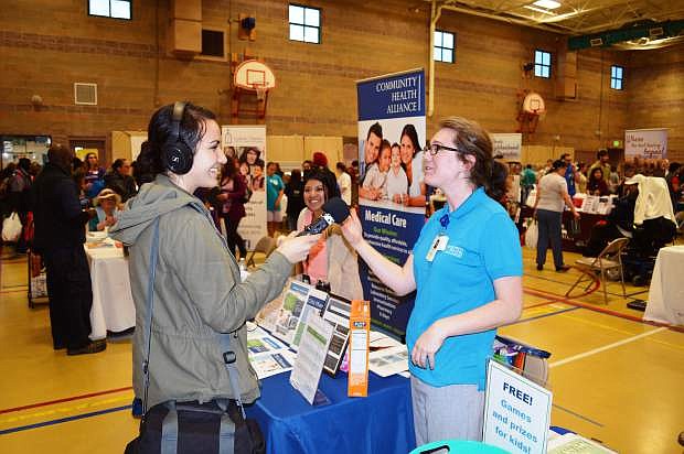 A Truckee Meadows Healthy Communities member talks to a participant at a health fair.