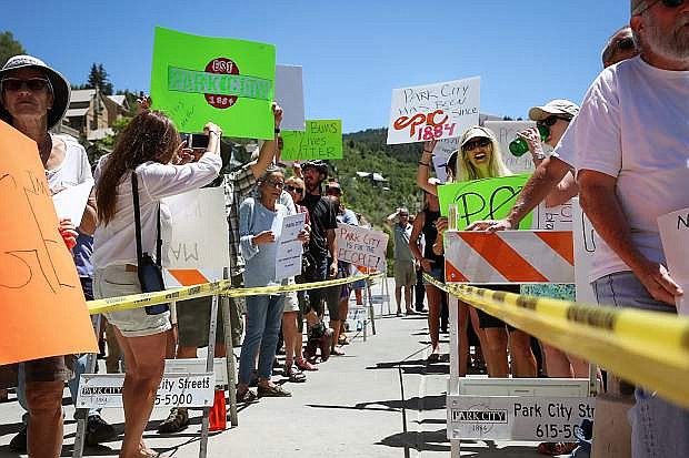 Protestors hold signs opposing Vail Resorts&#039; application for a trademark of &quot;Park City&quot; outside City Hall Wednesday afternoon.