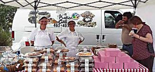 Mary Kropelnicki, left, and Makyla McCorkle, right, serve patrons of Fernley Farmers Market baked good they sell from The Bakery Gallery in Yerington.