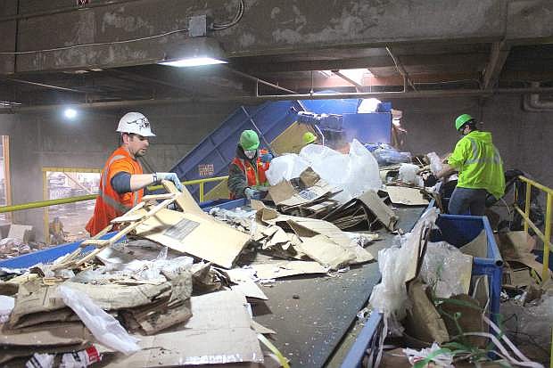 Workers at Nevada Recyling &amp; Salvage sift through debris for cardboard, plastics and paper.