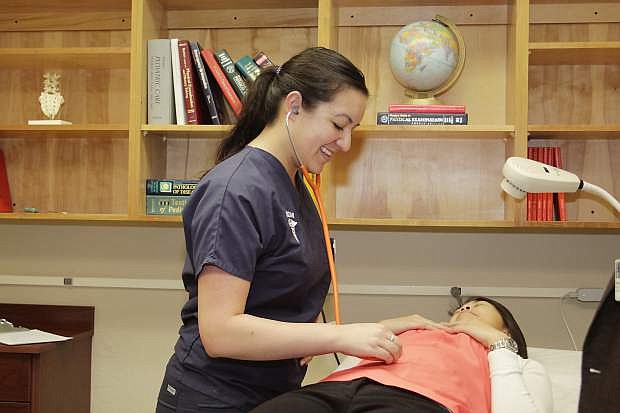 Medical student Shawnice Kraeber poses to examine a patient at a Student Outreach Clinic, held monthly by students at the University of Nevada, Reno School of Medicine.