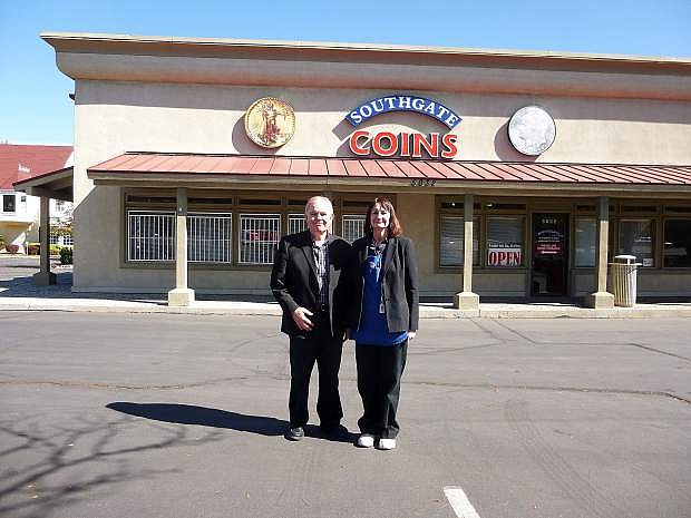 Owners Rusty and Marie Goe stand in front of  their coin shop that will be closing at the end of the month.