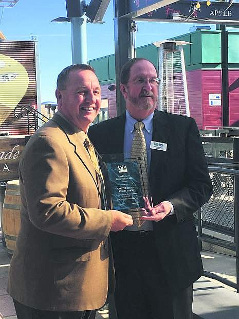 GNCU President and CEO Wally Murray and USDA Rural Development Business Program Director Herb Shedd stand outside at Greater Nevada field holding the 2016 National Lender of the Year award.