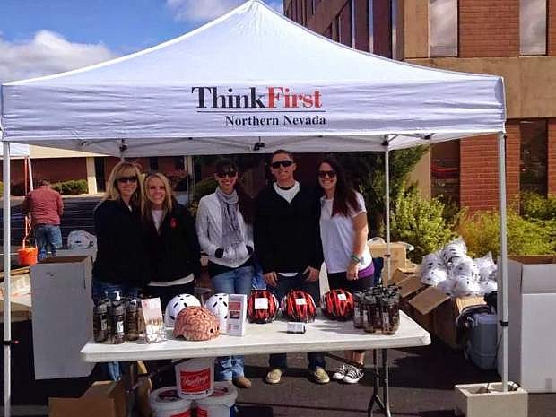 Volunteers with ThinkFirst Northern Nevada staff a booth at the 2014 Kids on Big Rigs event, offering free, properly fitted safety helmets to young people to encourage safety while enjoying an active lifestyle.