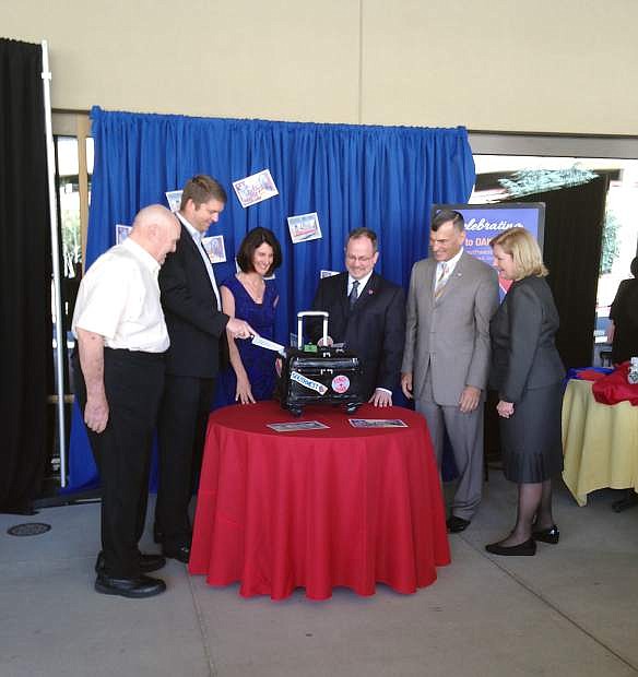 Mayor of Sparks Geno Martini, John Parker, senior business consultant - Capacity Planning for Southwest, Adam Decaire, managing director of network planning for Southwest, Jennifer Cunningham, interim managing director of RSCVA, Mike Kazmierski, CEO and president of EDAWN and Marily Mora cut the luggage shaped cake at the event.