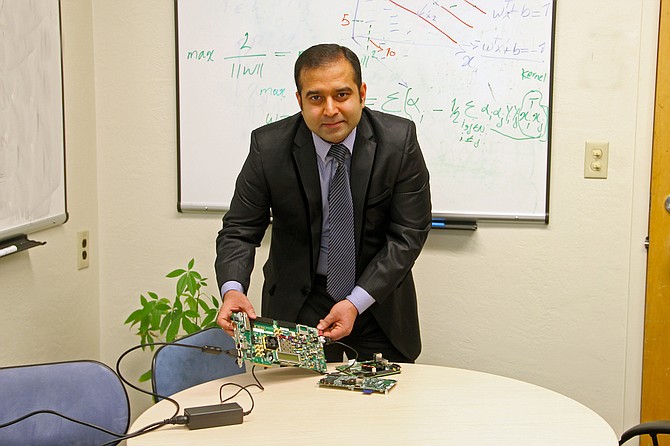 Arslan Munir, assistant professor of Computer Science and Engineering displays the test boards used to develop new architecture for electronic control units, or ECUs, that tested 48 times faster while using two-and-a-half times less energy than existing architectures. It also paves the way for more fully automated driverless cars. Photo courtesy of University of Nevada, Reno.