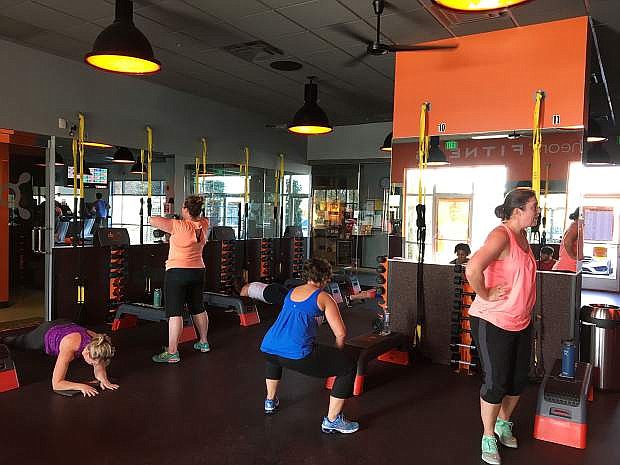 Orangetheory Fitness members lifting weights in the strength potion of a class.