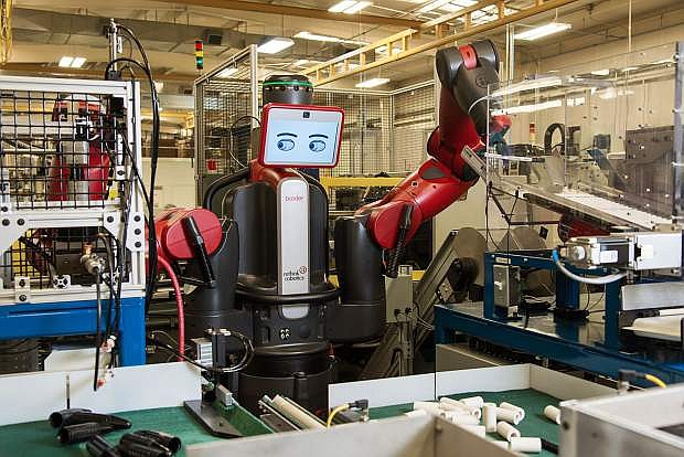 Baxter, a robot, works on a stenner pump.