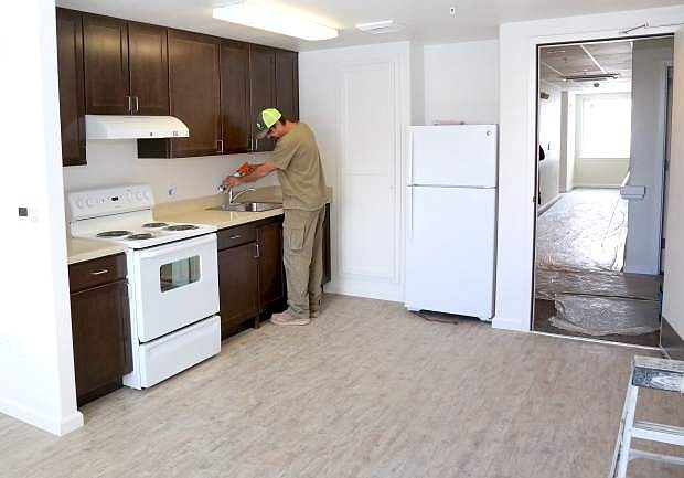Adam Glass with Q&amp;D Construction does finish work in one of the new apartment units at Richards Crossing on Monday.