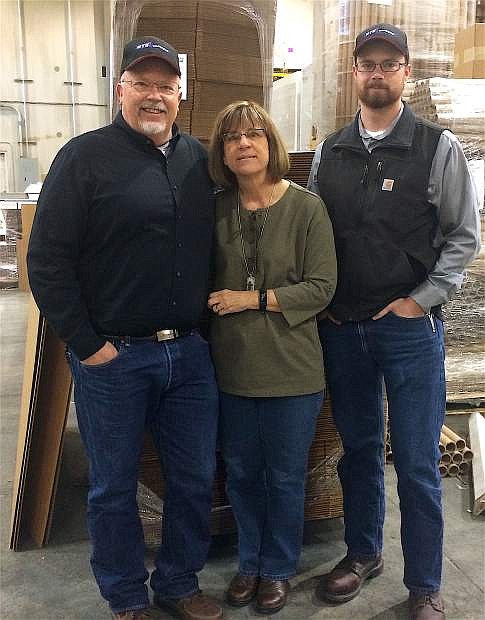 Kevin, left, and Shawna Smith and their son, William, pose in the warehouse of GTG Packaging amidst stacks of boxes, cardboard and packaging supplies. The couple have owned the store for 22 years.