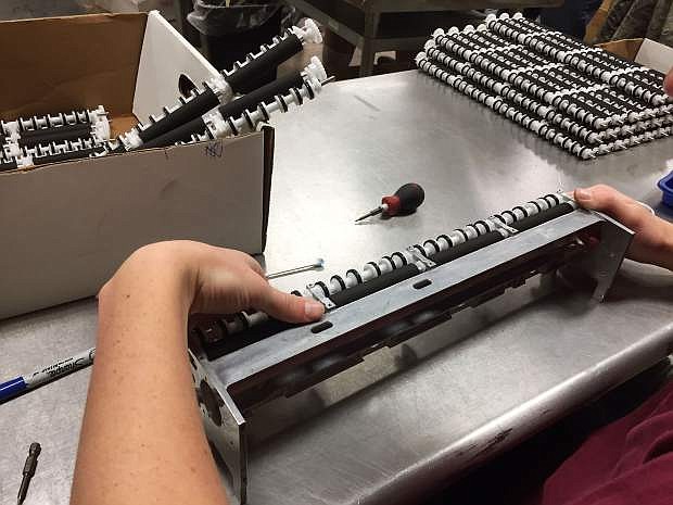 A worker at High Sierra Industries puts together an exit roller for a lottery machine.