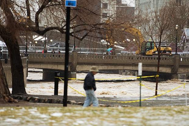 A person walking by the Truckee River in downtown Reno during the January flooding. The Truckee River Flood Management Project is working to mitigate economic impacts of future flood events through their Flood Project.