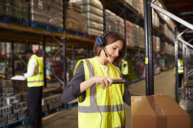 Woman using a barcode reader in a distribution warehouse. TMCC will offer a four-year logistics degree starting in fall 2017. 