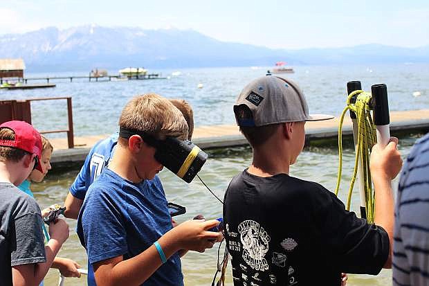 A STEM camp student watches the underwater footage from his robot with special goggles made by instructor David Wise.