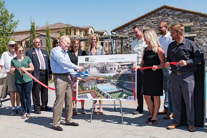 Jay Ryder, owner of Ryder Homes, cuts the ribbon during the celebration Aug. 25 to open the Village South Apartments as other dignitaries watch.