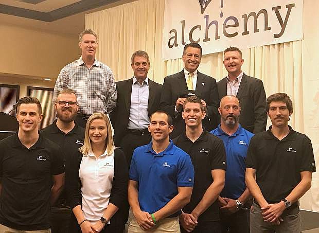 Governor Brian Sandoval, top row second from right, and the co-founders of Alchemy, Jim Carr, left, Bill Wilson, and Mike Duffield, pose during a press conference hosted by Economic Development Authority of Western Nevada to welcome the technology company to the community. Bottom row are members of the Alchemy staff who are also alumi of the University of Nevada, Reno.