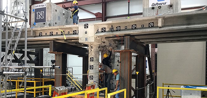 Graduate engineering students at the University of Nevada, Reno inspect damage to a 100-ton, 70-foot-long concrete bridge that was shaken in a live simulation to test new materials, connections and construction techniques with the goal of creating safer structures and quicker rebuilding times following earthquakes. 