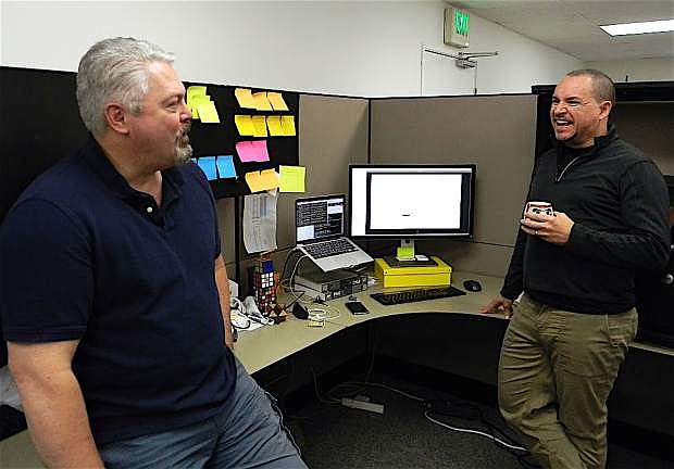 Greg Howard, left, and Jeff Urmston, founders of TrenLot, talk in their office.