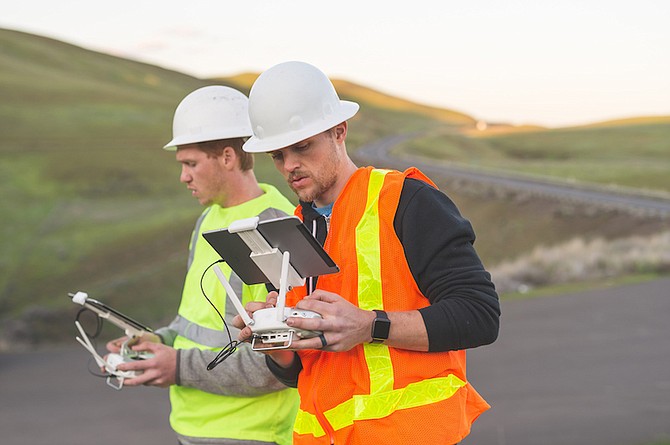 Engineers use a drone to inspect wind farms in this stock art photo. NV Energy uses drones to inspect power lines and is working on getting FAA approval for beyond visual line of sight flights.
