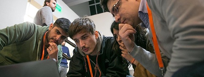 A hackathon team looks over challenge information at a previous Barrick&#039;s event.