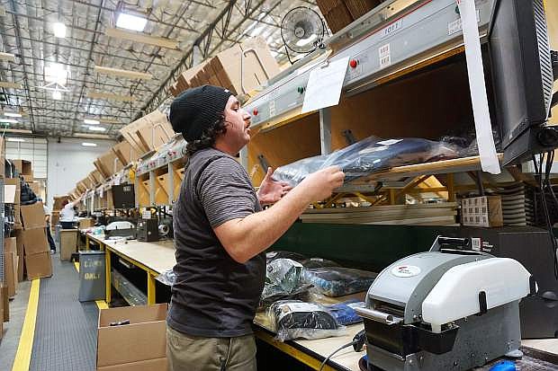 Tyson Trieger pulls down items to be packed and shipped from the Patagonia Distribution Center on Thursday, March 8, in west Reno.