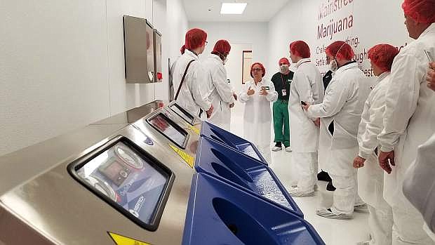 Employees of MedMen Mustang are required to wear lab coats, pants and hair nets and use high-strength automatic handwashing machines before entering the factory.