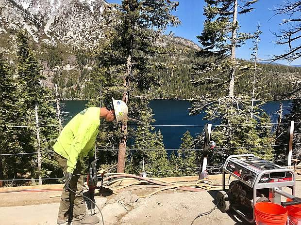 A man works on the road on State Route 89 in Emerald Bay earlier this year.
