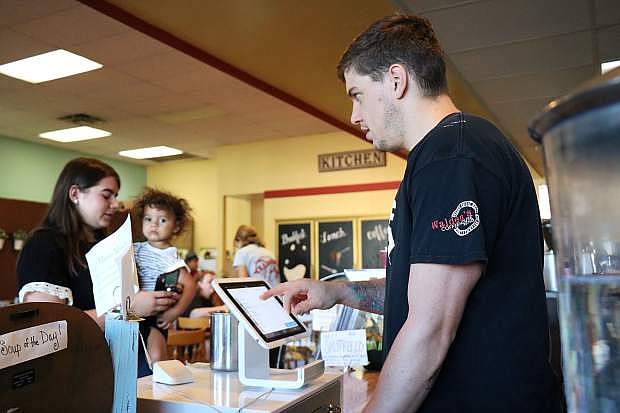 Barista JP Preston takes an order using the Walden&#039;s Coffeehouse&#039;s cloud-based point of sale system.