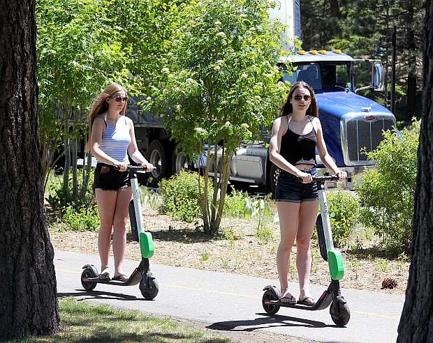 Girls ride Lime scooters alongside Highway 50 in South Lake Tahoe earlier this summer.