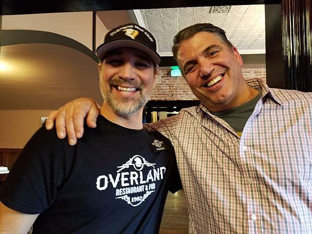 Server Tennesse Willis and Mark Estee, owner, celebrate the introduction of a new menu at Overland Restaurant &amp; Pub.
