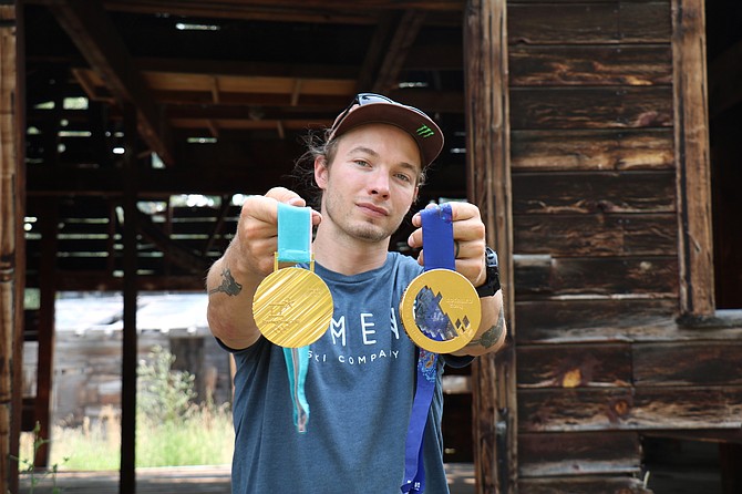 David Wise holds out his 2018 Winter Olympic gold medal (on left) and 2014 gold medal in his backyard in Verdi.