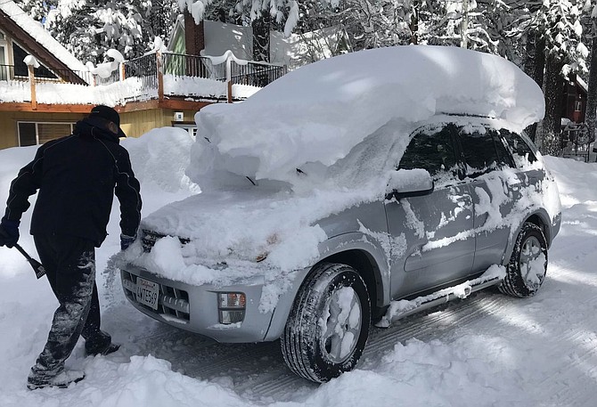 A man removes snow from his car after a winter storm this February.