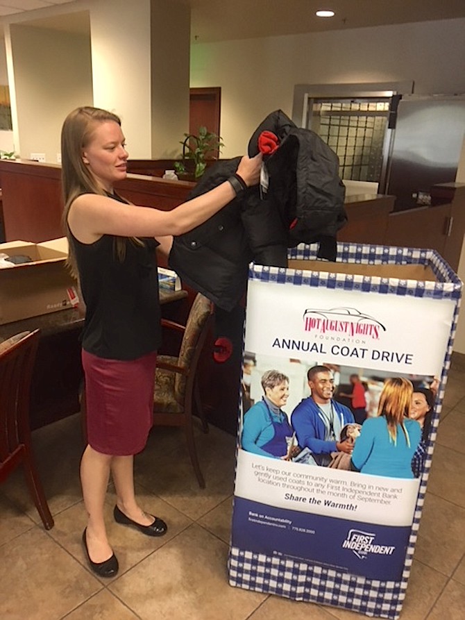 A First Independent Bank staff member drops a coat into one of the bank&#039;s bins during last year&#039;s drive.