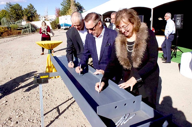 From left, Par Tolles, principal and CEO of Tolles Development Company; Chip Bowlby, president and CEO of Reno Land Inc.; and   Reno City Council member Naomi Duerr signed steel construction beams at the Oct. 17 event to celebrate ongoing construction at The Village at Rancharrah.