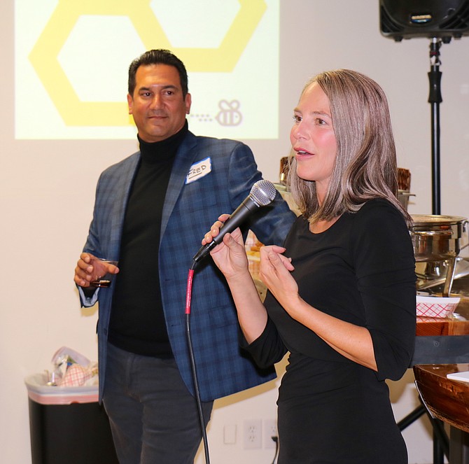 Tabitha Schneider, co-founder of Reno Hive, speaks about the coworking space as her business partner, Fred Turnier, looks on at the Oct. 23 launch party. 