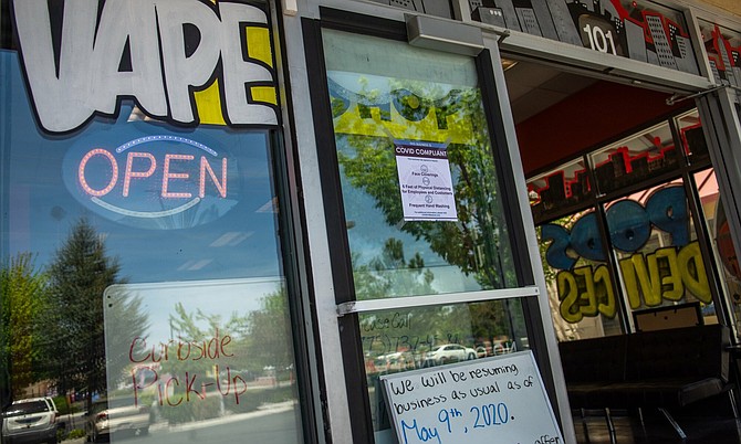 A Vape Shop in Sparks displays a &quot;COVID COMPLIANT&quot; sign on Saturday, May 9, 2020. 