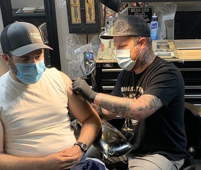 Rice Street Tattoo owner Tony Jackson, right, works on the shoulder of a client during an appointment in late June inside the Carson City shop.