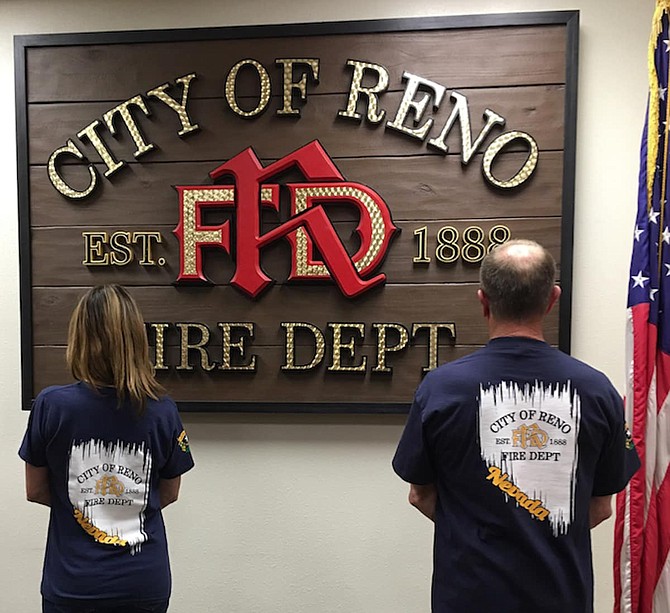 Two Reno Fire Department members show off examples of some of the gear being sold as part of the fundraiser.