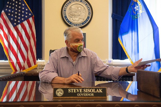 Gov. Steve Sisolak signs Assembly Bill 1 into law on Sunday, Aug. 2, 2020, inside his office in the Capital on the third day of the 32nd Special Session of the Legislature in Carson City.