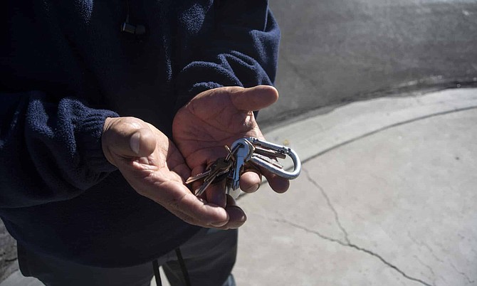 Enrique, who was recently evicted from his home, holds the keys to his truck in a Las Vegas neighborhood on Thursday, Nov. 12, 2020.