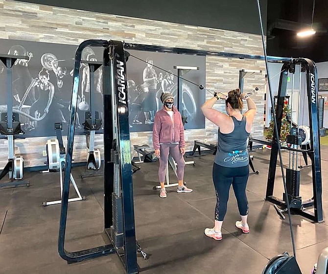EVOKE Fitness Training Complex owner Mena Spodobalski works with a client in early December at the Reno fitness center.